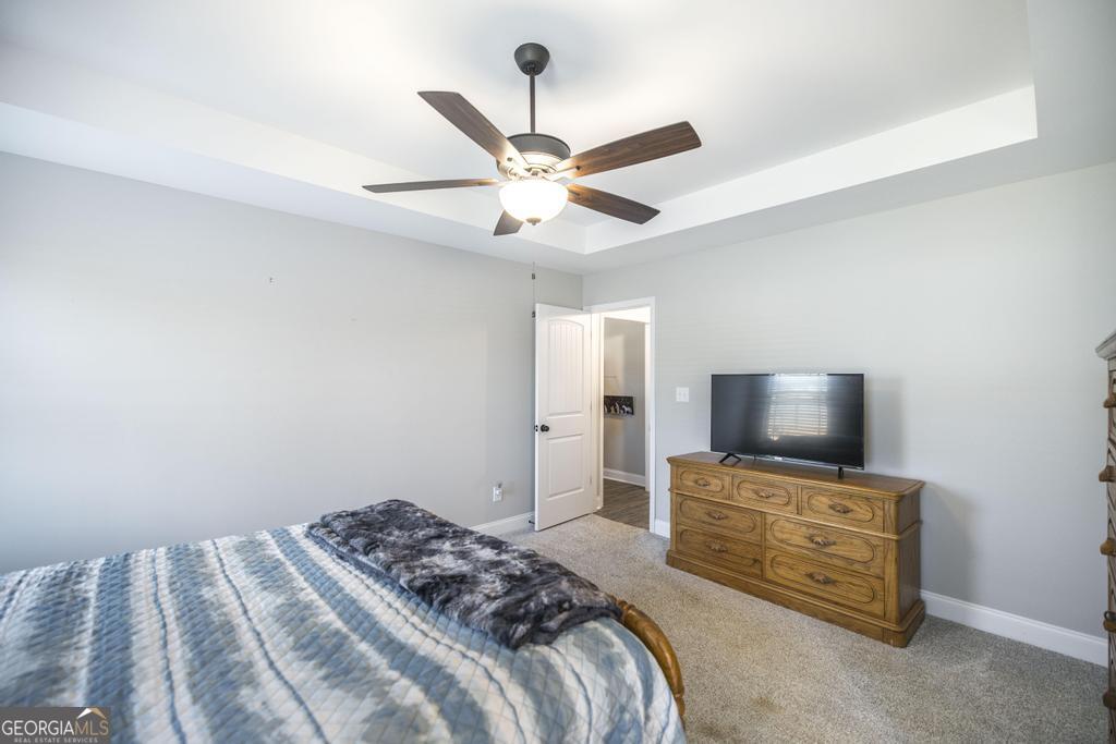 132 Sadie Heights Boulevard Perry, GA 31069 - Photo 16 of 29 a bedroom with a bed and a flat tv screen on a dresser