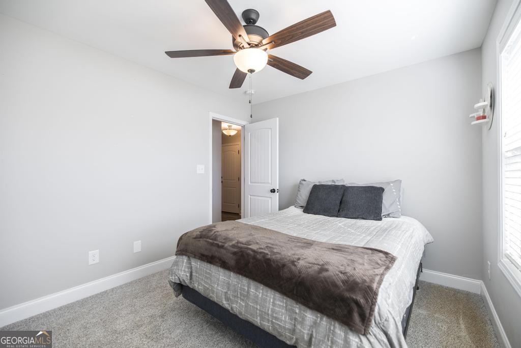 132 Sadie Heights Boulevard Perry, GA 31069 - Photo 20 of 29 a bedroom with a bed and a ceiling fan