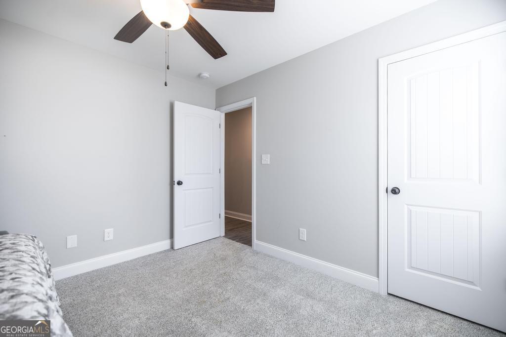 132 Sadie Heights Boulevard Perry, GA 31069 - Photo 23 of 29 an empty room with a ceiling fan and carpet