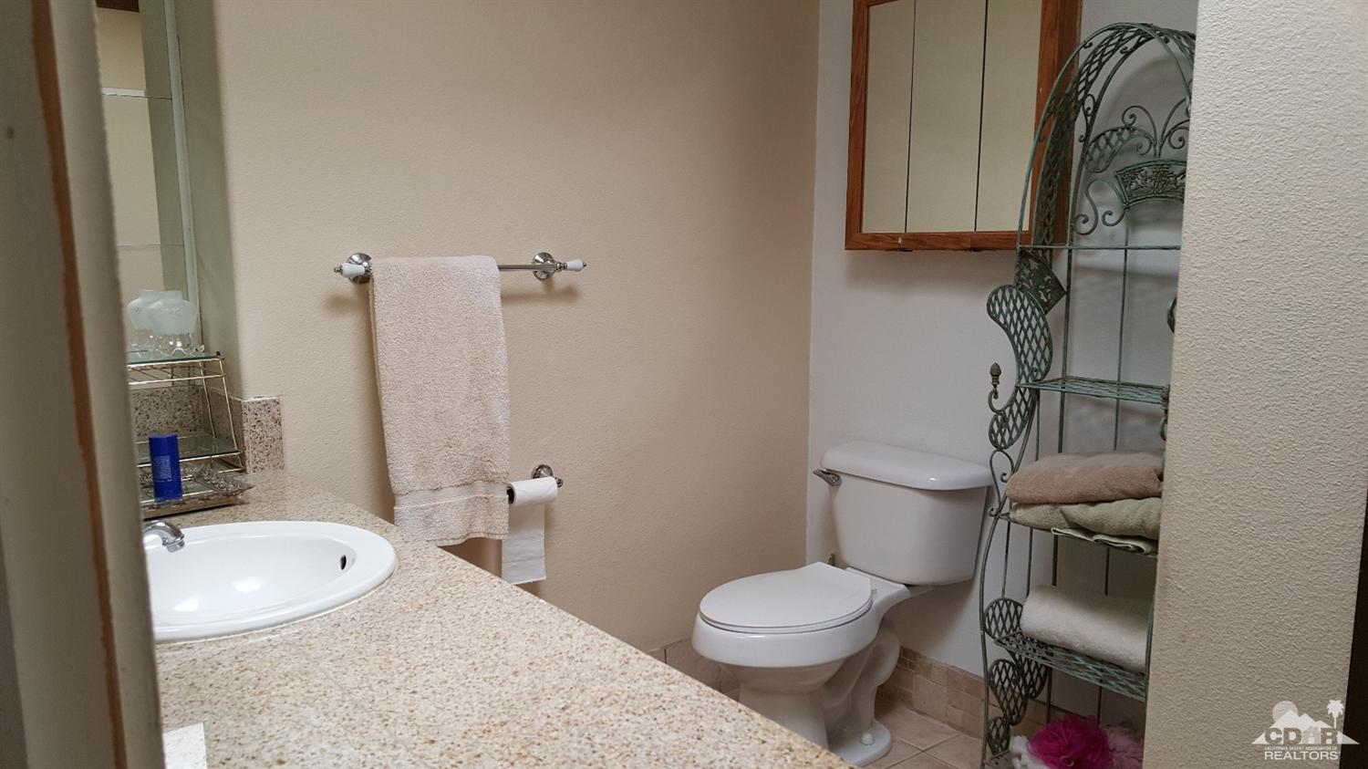 82320 Luce Court Indio, CA 92201 - Photo 7 of 11 a bathroom with a granite countertop toilet and a sink
