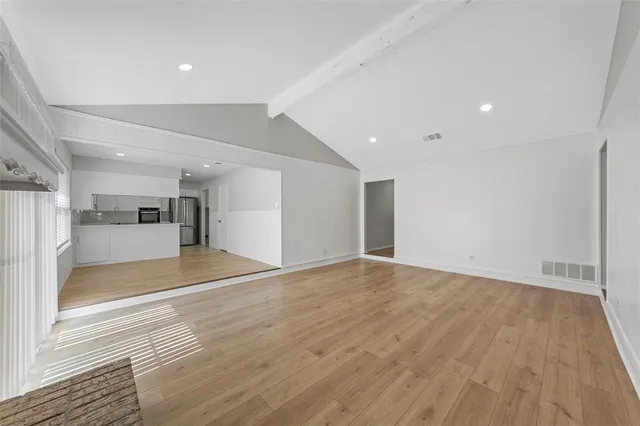 a view of empty room with wooden floor