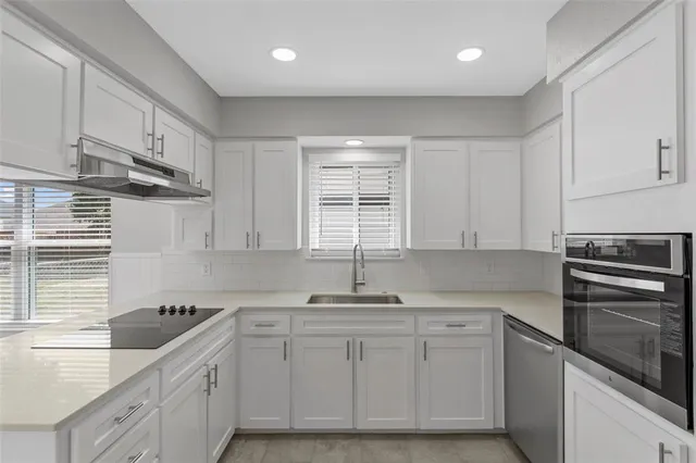 a kitchen with white cabinets and white appliances