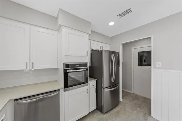 a kitchen with stainless steel appliances a refrigerator sink and microwave