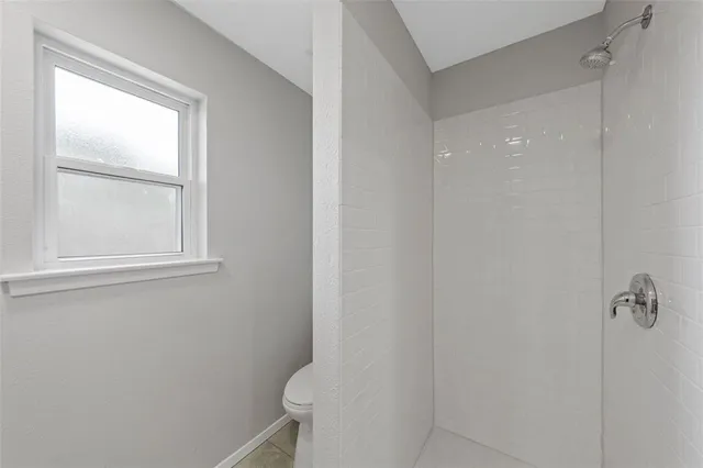 a bathroom with a toilet and a window