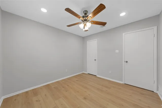 an empty room with window and ceiling fan