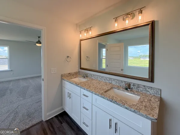 a bathroom with a granite countertop sink and a mirror