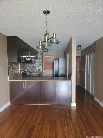a view of a kitchen with a sink and refrigerator