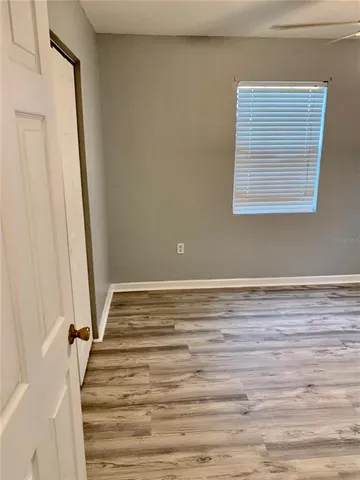 a view of a room with wooden floor and fan