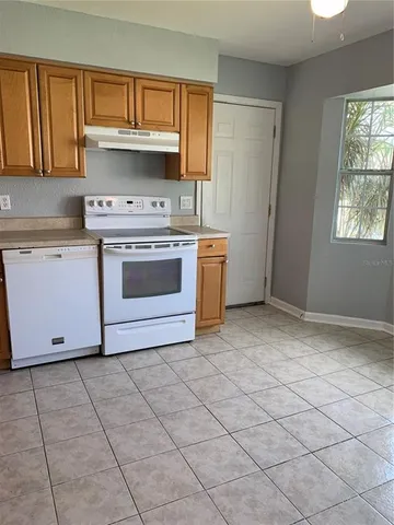 a kitchen with a stove top oven cabinets and a window