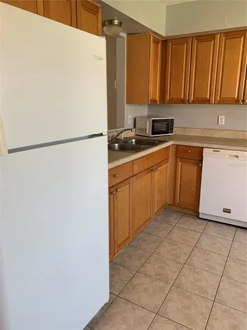 a kitchen with a refrigerator sink stove and cabinets