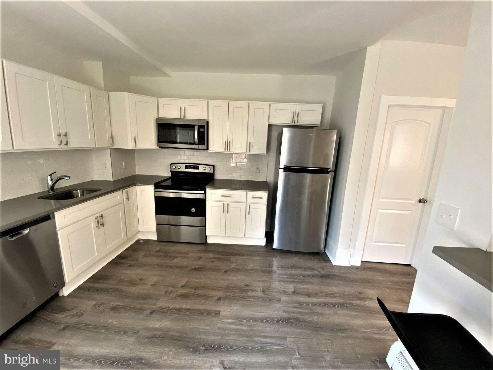 515 Thomas Street Bethlehem, PA 18015 - Photo 5 of 30 a kitchen with a refrigerator stove and white cabinets