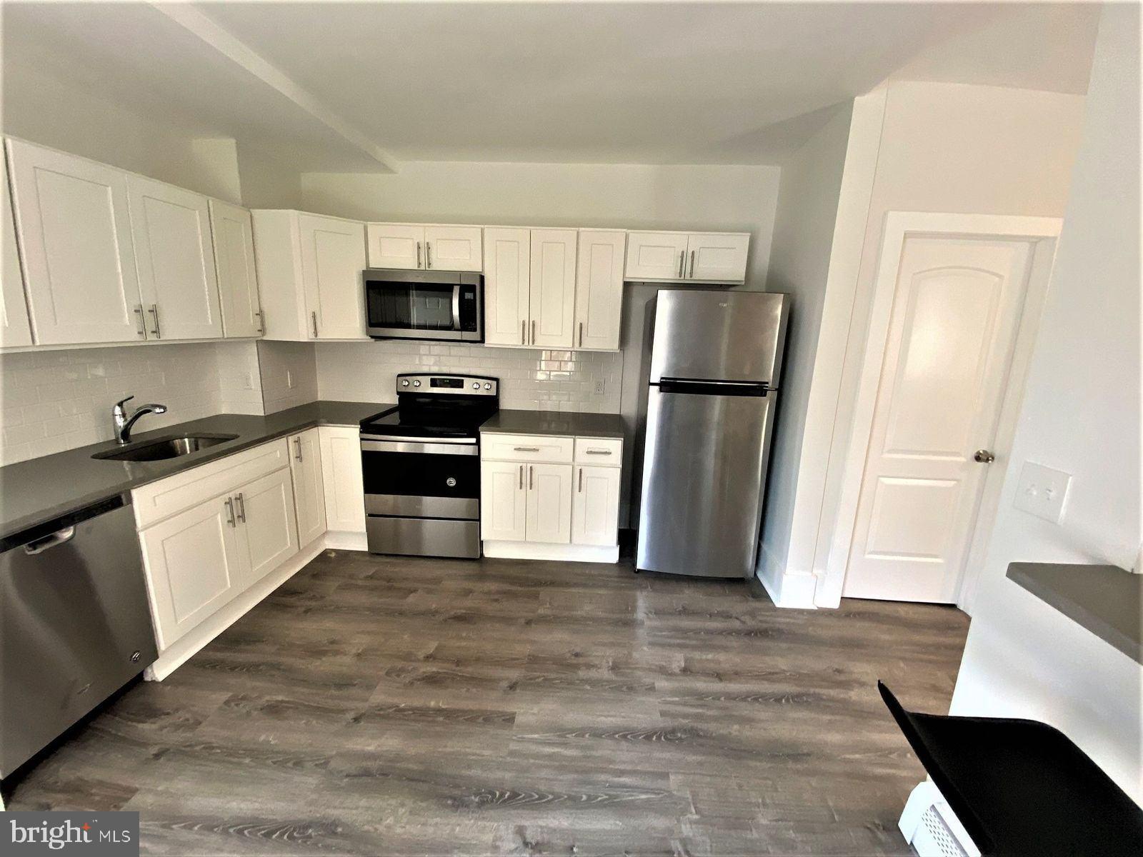 515 Thomas Street Bethlehem, PA 18015 - Photo 6 of 30 a kitchen with a refrigerator stove and white cabinets