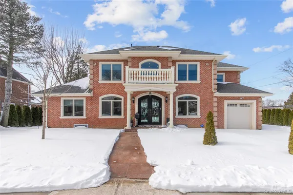 a front view of a house with a yard covered in snow