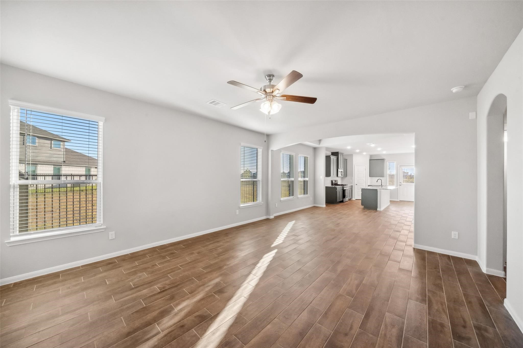 a view of an empty room with a window and wooden floor