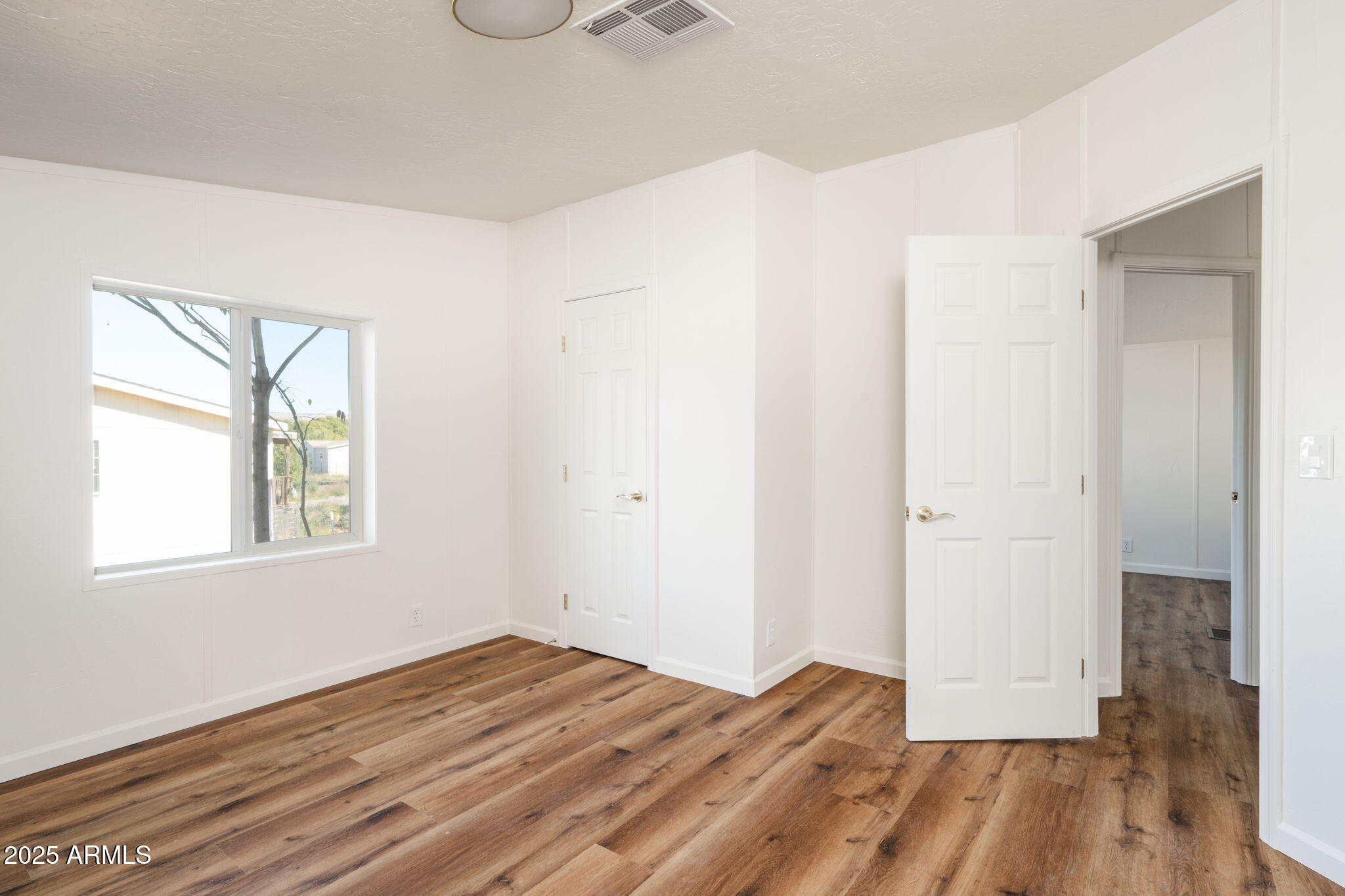 3278 East Ripple Road Camp Verde, AZ 86322 - Photo 25 of 33 an empty room with wooden floor and windows