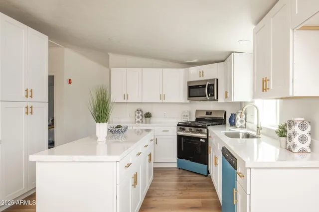 a kitchen with a sink a stove top oven and white cabinets