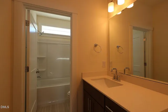 a bathroom with a granite countertop sink shower and a mirror