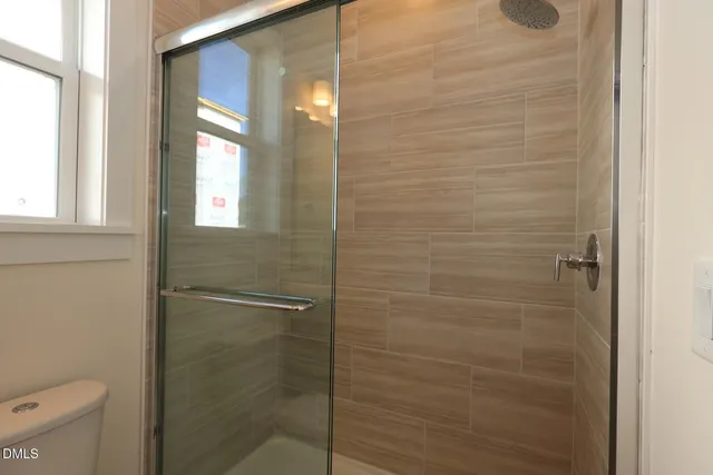 a bathroom with a toilet and a shower