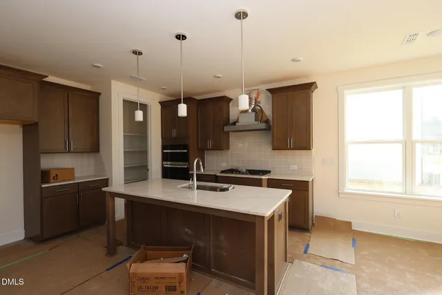 a kitchen with a sink a stove a refrigerator and a window