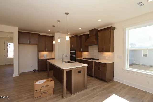 a kitchen with a sink a counter top space stainless steel appliances and a window