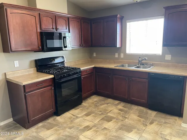 a kitchen with stainless steel appliances granite countertop a stove top oven a sink dishwasher and a microwave oven on the blue kitchen countertops