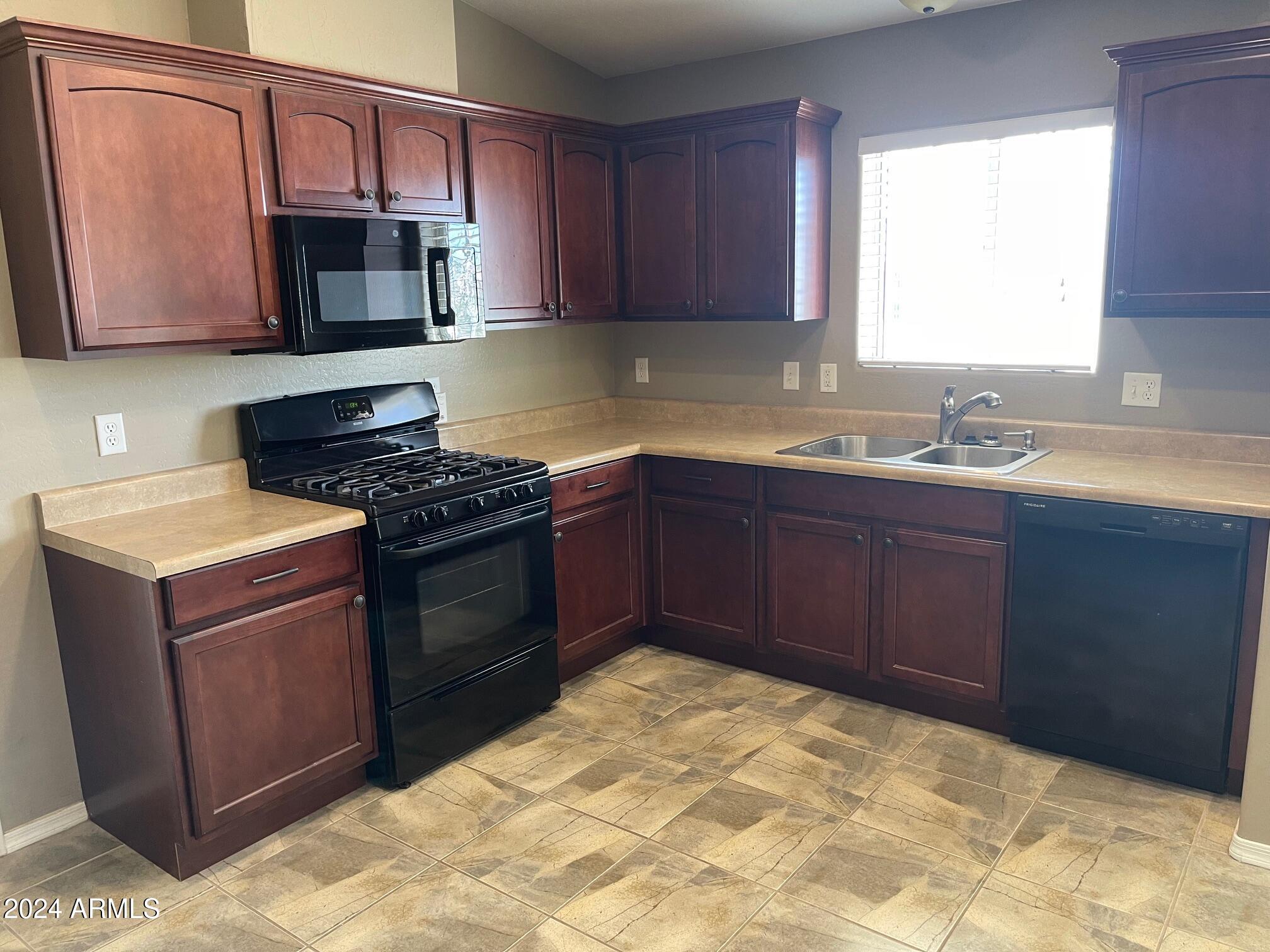 115 West 10th Street Casa Grande, AZ 85122 - Photo 2 of 14 a kitchen with stainless steel appliances granite countertop a stove top oven a sink dishwasher and a microwave oven on the blue kitchen countertops