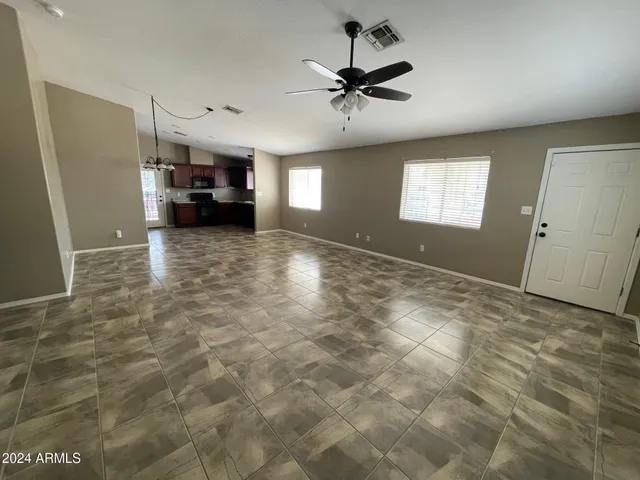 a view of empty room with a kitchen