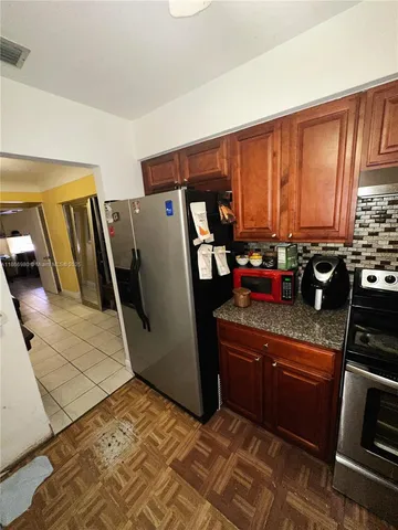 a kitchen with sink a refrigerator and a stove