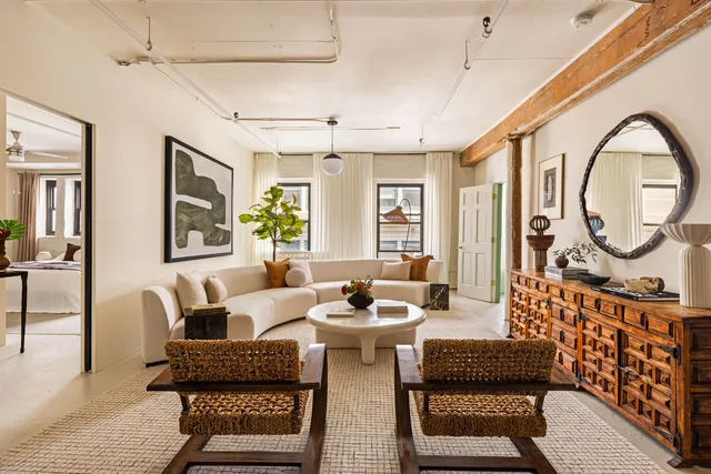 a living room with furniture a fireplace and a chandelier