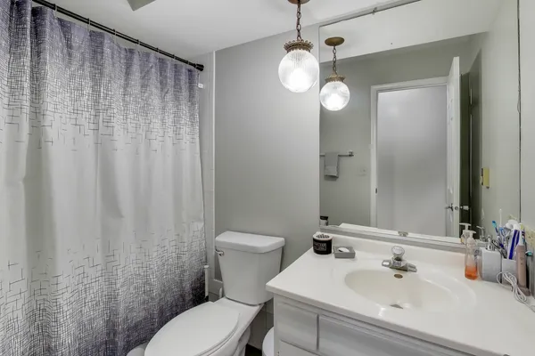 a bathroom with a sink a toilet and shower curtain