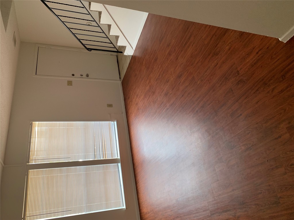 8112 Sonnet Avenue, Unit 102 Austin, TX 78759 - Photo 2 of 11 an empty room with wooden floor and windows