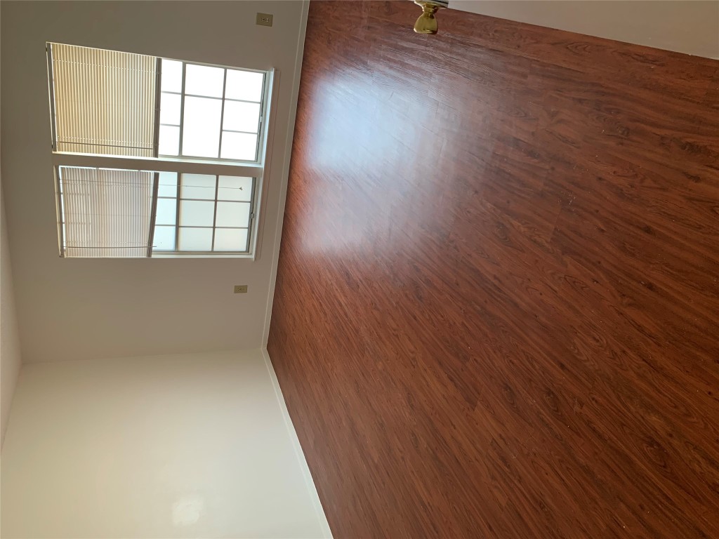8112 Sonnet Avenue, Unit 102 Austin, TX 78759 - Photo 8 of 11 an empty room with wooden floor and windows