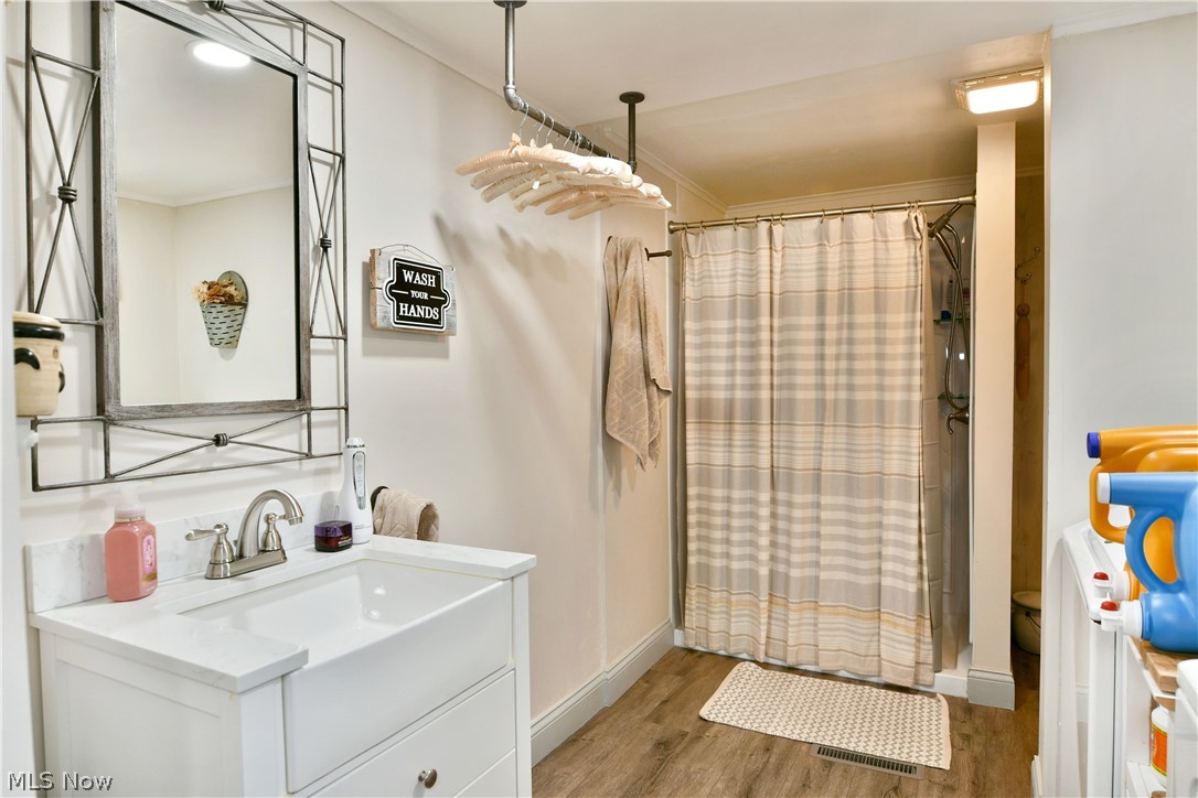 8683 King Graves Road Northeast Warren, OH 44484 - Photo 26 of 50 Bathroom featuring a white vanity with integrated sink, brushed nickel faucet, and a decorative framed mirror