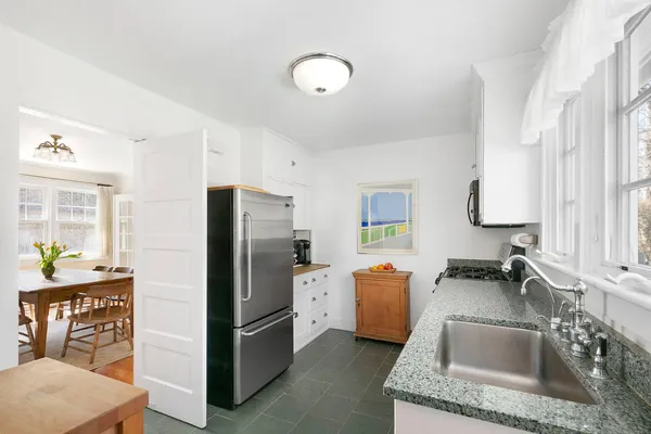 a kitchen that has a sink cabinets and refrigerator