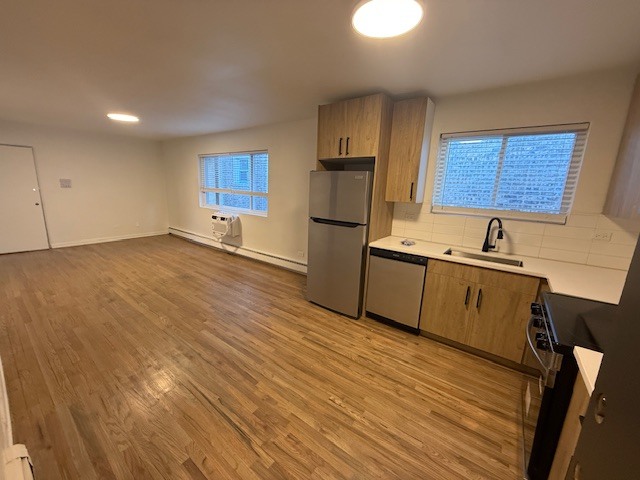 7357 North Winchester Avenue, Unit 2M Chicago, IL 60626 - Photo 3 of 12 a kitchen with granite countertop a sink cabinets stainless steel appliances and a window