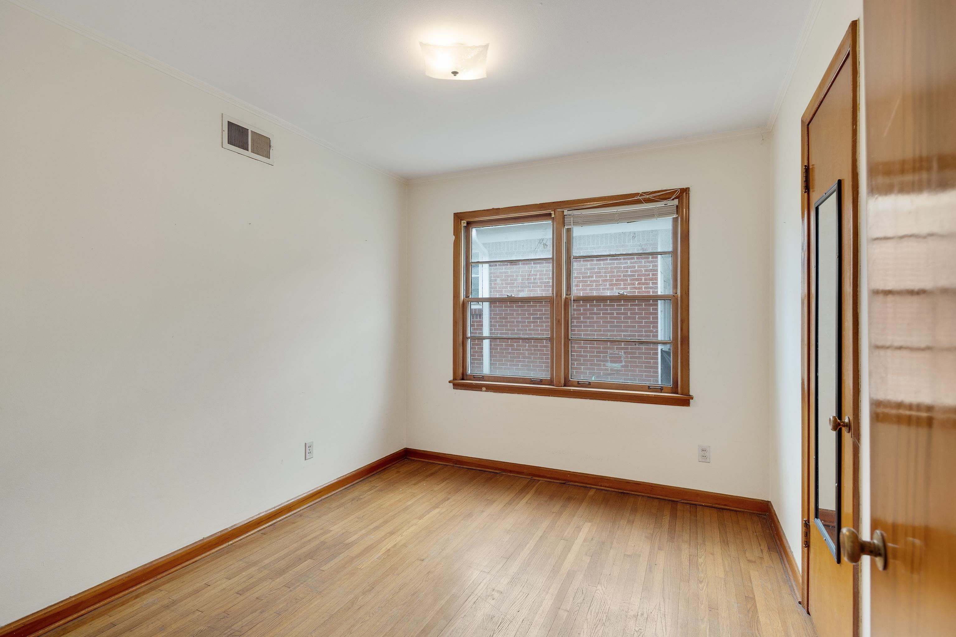 4928 Flamingo Road Memphis, TN 38117 - Photo 17 of 30 an empty room with wooden floor and windows