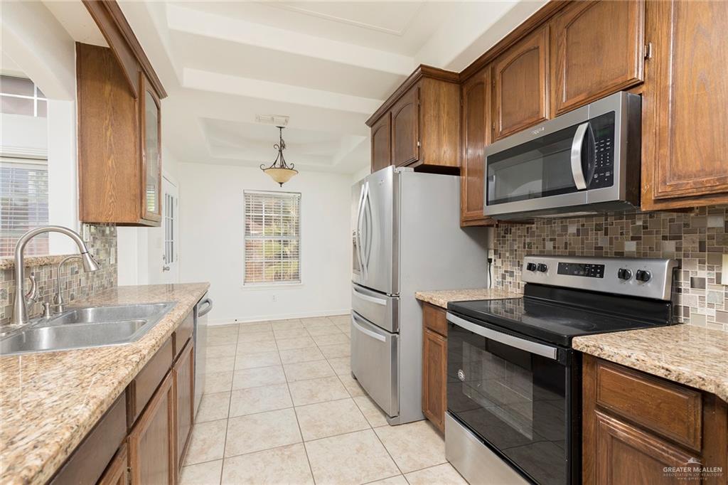 1909 Ezekiel Street Edinburg, TX 78542 - Photo 6 of 16 a kitchen with granite countertop a sink stove and refrigerator