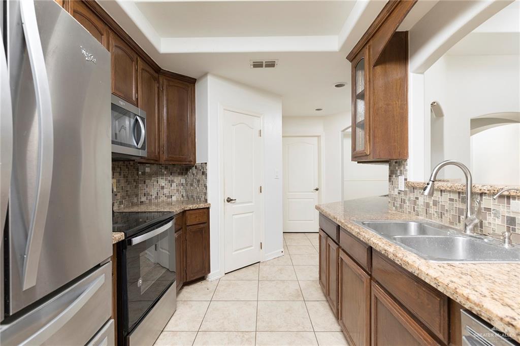 1909 Ezekiel Street Edinburg, TX 78542 - Photo 7 of 16 a kitchen with stainless steel appliances granite countertop a sink stove and refrigerator