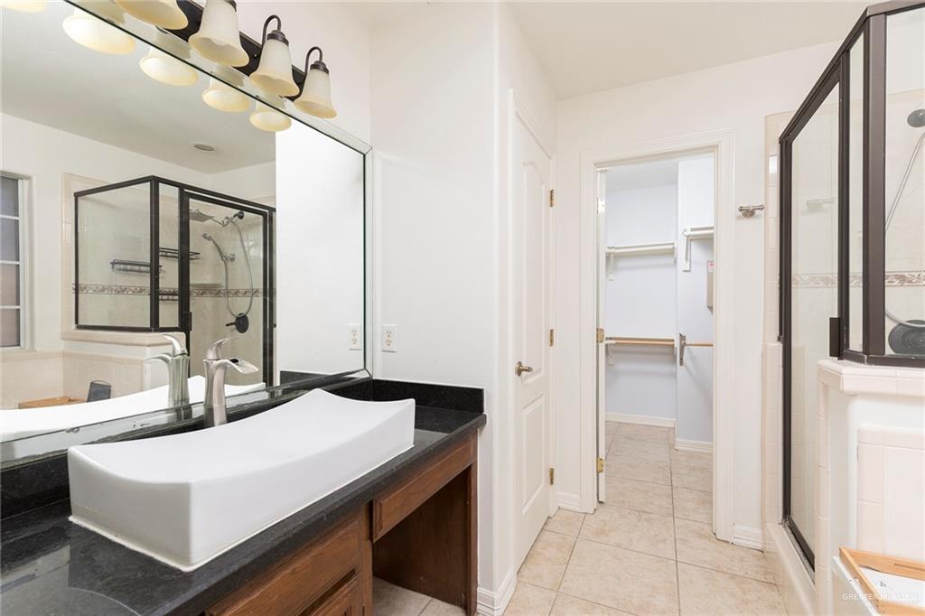 1909 Ezekiel Street Edinburg, TX 78542 - Photo 9 of 16 a bathroom with a sink a mirror and a shower