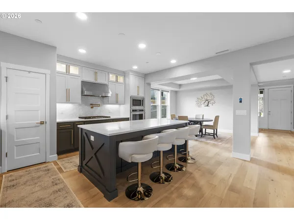 a kitchen with kitchen island a dining table chairs and a refrigerator