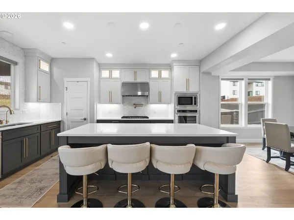 a large kitchen with kitchen island a dining table and chairs