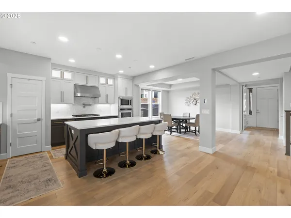 a living room with stainless steel appliances kitchen island granite countertop furniture and wooden floor