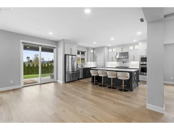 a kitchen with stainless steel appliances kitchen island granite countertop a refrigerator and a stove top oven
