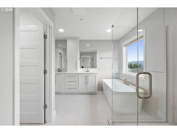 a bathroom with a double vanity sink a toilet a mirror and shower