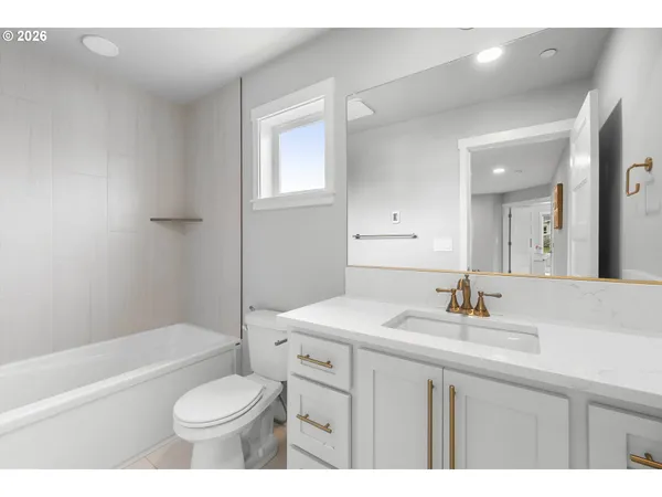 a bathroom with a sink toilet vanity and bathtub