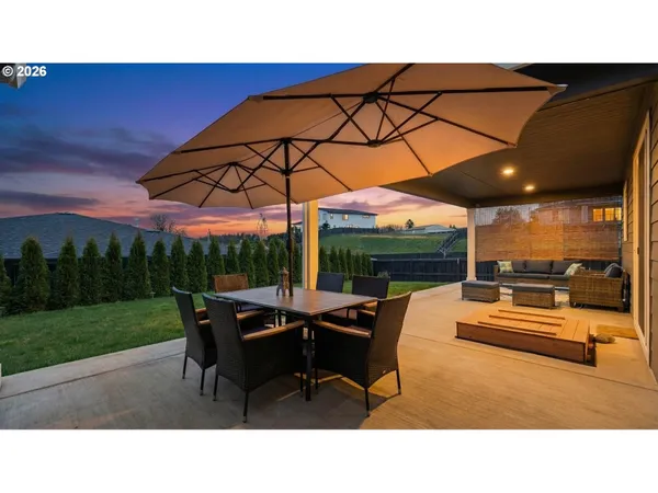 a backyard of a house with table and chairs