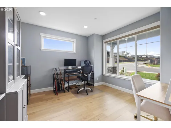 a living room with furniture a large window and wooden floor