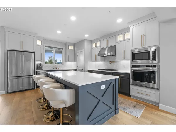 a kitchen with kitchen island a sink stainless steel appliances and cabinets