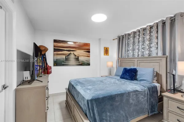 a bedroom with a bed and a wooden floor