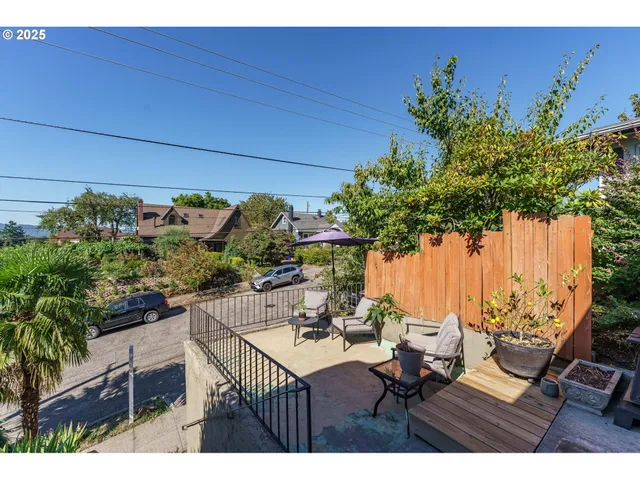 a view of a balcony with chairs potted plants with wooden floor and fence